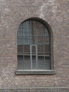 großformatiges Stahlfenster mit Halbkreis, Festverglasung mit einem Öffnungsflügel mittig
